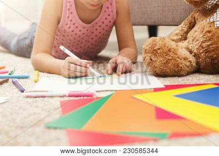 Happy Little Girl Drawing. Cute Kid Lying At Home On The Floor Among Cologed Paper And Pencils. Diy,