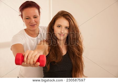 Physiotherapy - Young Woman Making Arm Exercises With Therapist For Rehabilitation Of Injured Arm
