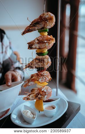 Shrimps Oe Prawns Served On A Vertical Skewer In An Restaurant.