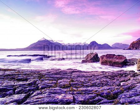 The Stony Beach And Cliff Of Rocky Bay. Blue Tones Of February Sunset, Pink Horizon.  Dark Slipery B