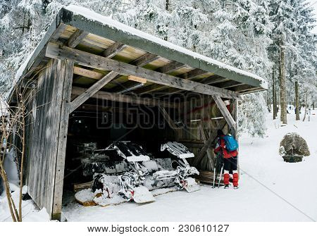 Mummelsee, Germany - Feb 18, 2018: Skier Resting Near The Garage Of The Modern Snow Plough Groomer I