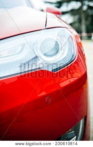 Paris, France - Nov 29, 2014: New Red Tesla Model S Detail Of The Bi-xenon Led Headlight Lamps On Th