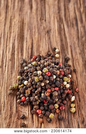 Black, Red And White Peppercorns Isolated On Dark Wooden Vintage Background. Heap Of Spice. Mix Of D