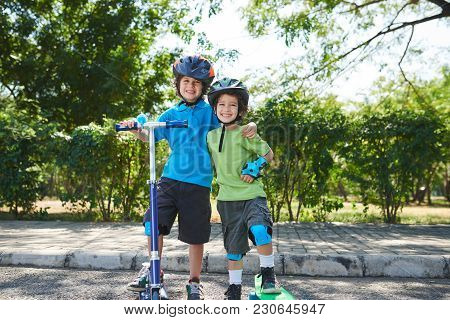 Two Hugging Happy Smiling Brothers In Helments