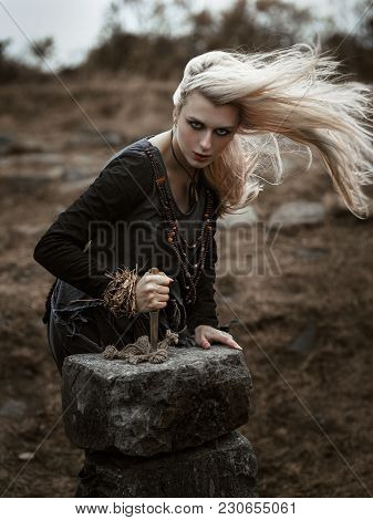 Witch In A Long Black Dress Walking Through The Village In The Dark