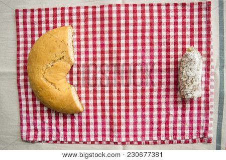 Piece Of Hot Salamy Put Near A Savoury Doughnut On A Red Napkin