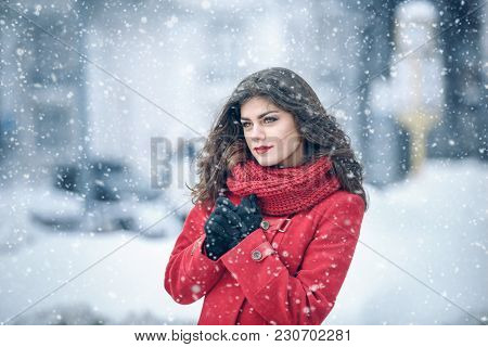 Winter. Girl Brunette Capless Smiles On The Background Of Snow. Close-up. Hair Develops. Wind And Sn
