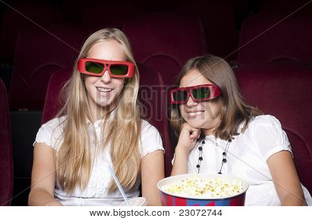 zwei schöne Mädchen, die einen Film im Kino