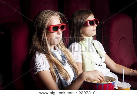 zwei schöne Mädchen, die einen Film im Kino