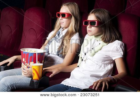 Zwei schöne Mädchen, die einen Film im Kino