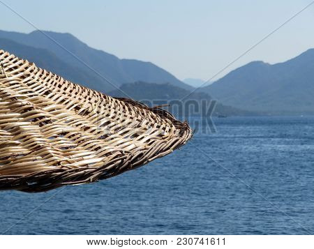 Wicker Sun Umbrella On The Beach. Seaside Resort On The Mountainous Coast. Vacation Background