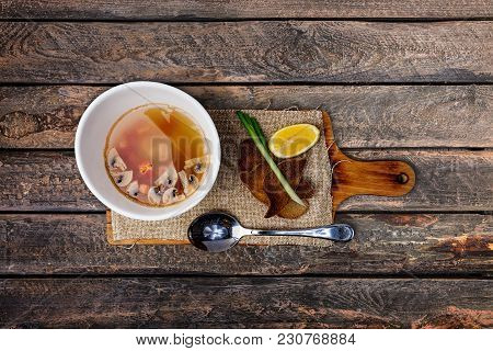 Mushroom Soup With Bread In Ceramic Bowl Served On The Rustic Cutting Board With A Spoon And Linen N