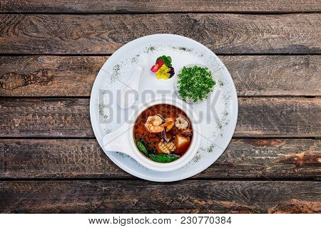 Miso Soup With Prawns In A White Ceramic Bowl, Served On The White Plate And Grey Wooden Background.