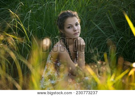 The Young Beautiful Girl, With A Bouquet Of Flowers, Has A Rest And Enjoys Beauty Of The Nature In T
