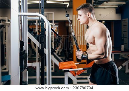 Bodybuilder Doing Heavy Weight Exercise For Triceps With Cable In The Gym