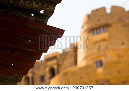 Roof Of Shed With The Sandstone Walls Of A Fort In The Distance And Blurred Out. Shows A Comparison 
