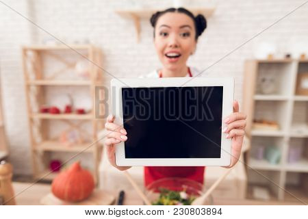 Culinary Blogger Girl In Red Apron Holds Up Blank Tablet To Camera.