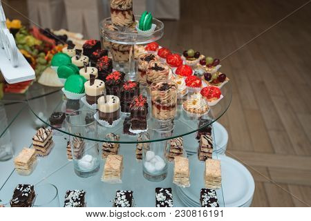Candybar In A Restaurant. Decorated White Table Fool Of Sweet Pastry. Wedding Sweets. Tray With Slic