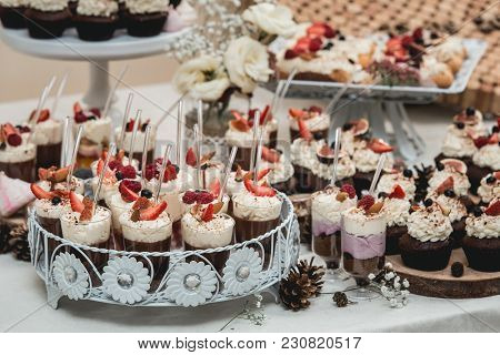 Candybar In A Restaurant. Decorated White Table Fool Of Sweet Pastry. Wedding Sweets.