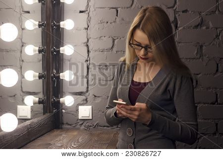 Closeup Of Sad Teenage Girl Lying In Bed Using Her Mobile. Young Pretty Woman With Bored Expression 