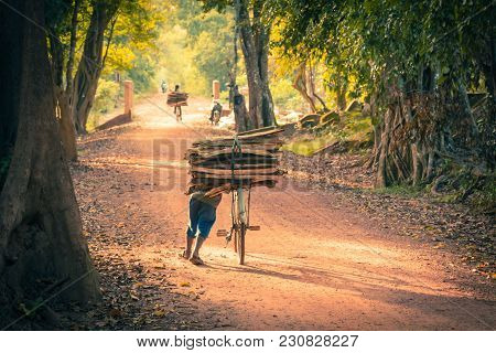 Cyclist On Dirt Road In The Jungle. Cambodia