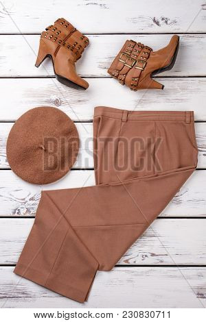 Set Of Brown Colored Women Clothes. Pair Of Brown Heel Shoes, Cap And Pants. Vertical View, Bright B