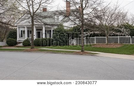House In Any Town With White Picket Fence Shrubs Trees Front Porch