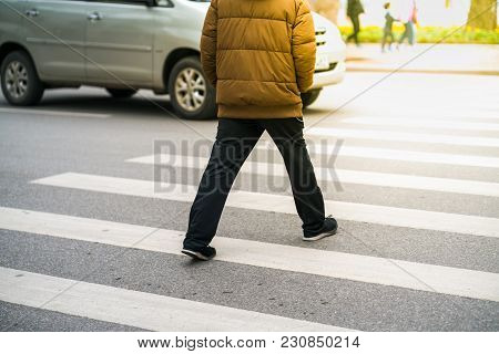 People Walking Across A Street While Cars Keep Running On Street In Hanoi, Vietnam. Closeup