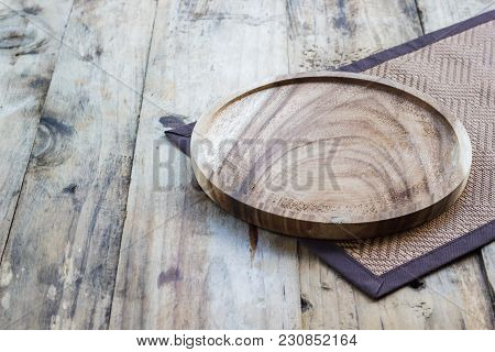 Empty Wooden Plate On Wood Table. Copy Space. Wood Plate For Food Or Vegetable Serving To Customers.