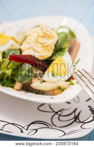 Potato Salad With Red Beet, Smoked Herring, Egg And Soy-bean Mayonnaise. Close-up Photo