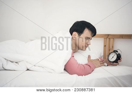 Man Wake Up Doing Turn Off Alarm Clock In The Morning. He Tired And Lazy Do Work.