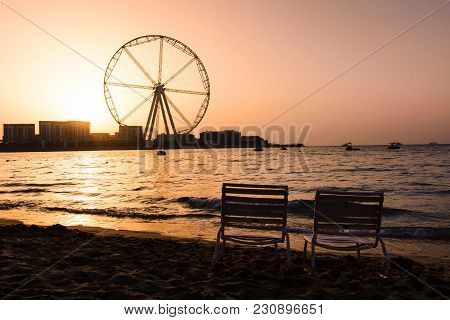 Two Sunbeds With Ain Dubai Ferris Wheel View At Jbr Beach At Sunset