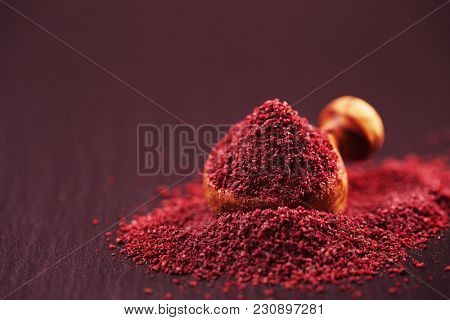 Ground Red Sumac Berries spice on black plate