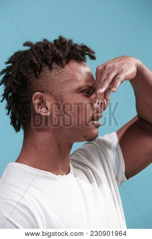 Young Man With Disgusted Expression Repulsing Something, Isolated On The Blue