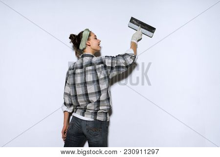 Zealous Young Girl Builder Levels The Walls With A Spatula