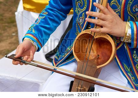 Playing A Musical Instrument Kobyz.
The Kobyz Or Qıl-kobız Is An Ancient Kazakh String Instrument. I