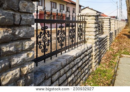 Black Wrought Iron And Cut Stone Fence