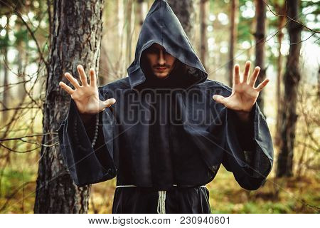The Black Monk Pointing His Finger In The Woods