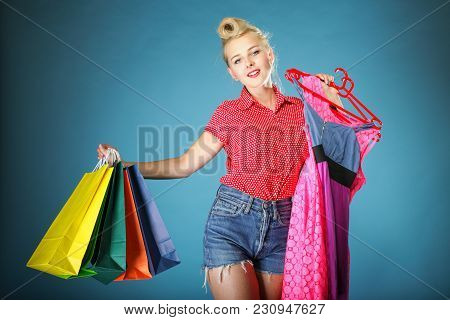 Retro Style. Shopper Woman Happy Shopping Buying Clothes. Pinup Girl Holding Olourful Shopping Bags 
