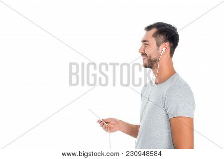 Side View Of Smiling Man With Smartphone In Earphones Listening Music Isolated On White