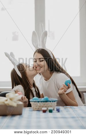 Mother And Daughter Together At Home Easter Preparation In Bunny Ears Sitting Girl Kissing Mom