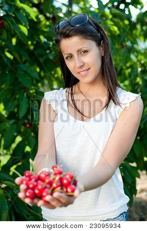 Krásná mladá dívka výdeje třešně