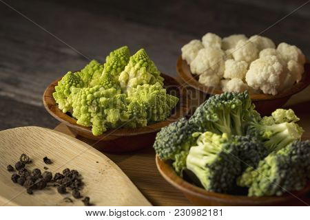 Fresh Pieces Of Romanesco Broccoli, Broccoli And Cauliflower In Small Rustic Wooden Bowls. Selective