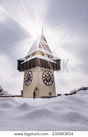 Sun Flares Over Snow Covered Uhrturm Clocktower Landmark Of City Graz On Hill Schlossberg In Winter