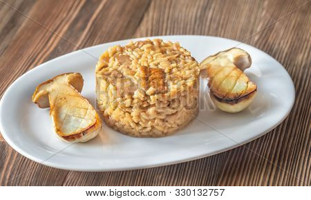 Risotto With Porcini Mushrooms On The White Plate