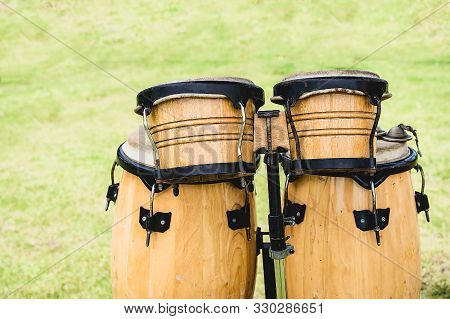 Close Up Image Of Small Wooden Ethnic Drums Isolated On Green Background. Drums Of Thailand Style.