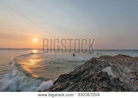 Surfers Go Out To Enjoy The Waves During Sunset At Snapper Rocks, Queensland, Australia.