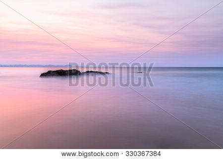 Long Exposure Of Rocks In The Ocean During Sunset On A Cloudy Day In Snapper Rocks, Queensland, Aust