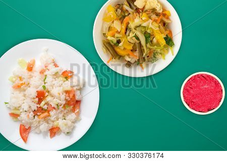 Rice With Vegetables On A White Plate Top View, White Rice With Vegetable Salad And Sauce On A Green