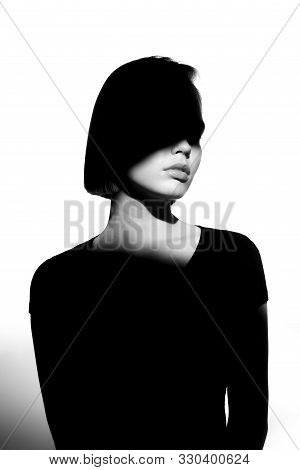 Fashionable Beauty Portrait. Black Silhouette On White Background. Girl With A Spot Of Light On Her 